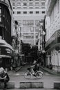 Vertical grayscale shot of a bicyclist on Nguyen Hue Street, Ho Chi Minh City, Vietnam