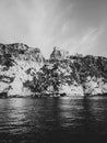 Vertical grayscale shot of castle ruins on a cliff over water at the Tremiti Islands in Puglia,Italy Royalty Free Stock Photo