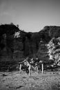 Vertical grayscale shot of a female in a swimsuit doing a trick on sands