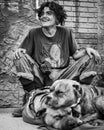 Vertical grayscale shot of a homeless man and his dog on a street in Moose Jaw, Canada