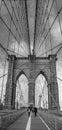 Vertical grayscale shot of people walking on Brooklyn Bridge in NYC, USA Royalty Free Stock Photo