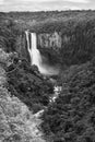 Vertical grayscale shot of a waterfall on a mountain