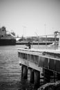 Vertical grayscale shot of a wooden harbor on a river