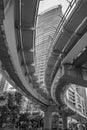 Vertical grayscale undershot of an elevated junction of the expressway, skyscrapers, sky background