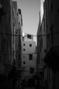 Vertical grayscale view through old buildings in medina (old town)