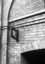 Vertical grayscale view of the platform 9 and three quarters sign on the stone wall