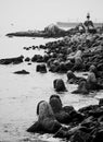 Vertical grayscale view of stone formations at the coastline on a lighthouse background, Valparaiso