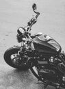 Vertical grey scale shot of a beautiful black motorcycle by the street