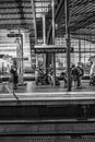 Vertical greyscale shot of Berlin Hauptbahnhof railway station and people on the platform