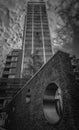 Vertical greyscale shot of a high rise building under the gloomy cloudy sky Royalty Free Stock Photo