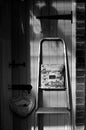 Vertical greyscale shot of a ladder by the wooden door of a brick house