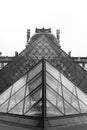 Vertical greyscale shot of the pyramid of the Louvre Museum in Paris, France