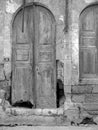 Vertical greyscale shot of a weathered wooden door of an old building in Alacati, Turkey