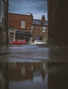 Vertical ground level shot of shops in Hale Village on a rainy day, United Kingdom