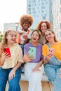 Vertical. Group of teenage girls using a mobilephone. Young women watching their smart phones. Female friends sharing on Royalty Free Stock Photo