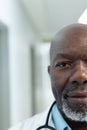 Vertical half face portrait of senior african american male doctor in hospital corridor, copy space Royalty Free Stock Photo