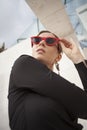 Vertical headshot of happy and cheerful mature woman outdoor, wearing red sunglasses. Royalty Free Stock Photo