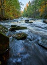 Vertical high angle long exposure view of a river flowing in a forest