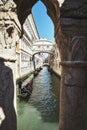 Vertical high angle shot of a beautiful canal with gondolas in Venice, Italy