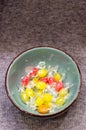 Vertical high angle shot of a ceramic bowl filled with colorful hard-boiled wrapped candies Royalty Free Stock Photo