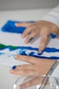 Vertical high angle shot of a child painting with his finger with blue paint on a white table Royalty Free Stock Photo