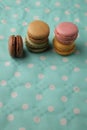 Vertical high angle shot of colorful macarons on a blue spotted surface Royalty Free Stock Photo