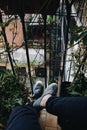 Vertical high angle shot of the legs of a person sitting in the balcony