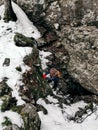 Vertical high angle shot of a person climbing cliffs during winter