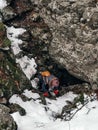 Vertical high angle shot of a person climbing cliffs during winte