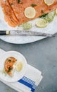 Vertical high angle shot of a plate of uncooked fish with lemons and herbs on an outdoor table