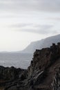 Vertical high angle shot of rocks on the shore of the sea on a gloomy day Royalty Free Stock Photo