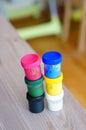 Vertical high angle shot of two colorful paint container stacks on a table Royalty Free Stock Photo