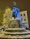 VERTICAL: Historic bronze statue of Preseren and his muse is covered in snow.