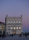 Vertical: An historic building, part of the Praca do Comercio during twilight.