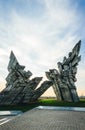 Vertical of the historical Ninth Fort memorial under the cloudy blue sky in Lithuanian