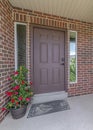 Vertical Home with red brick exterior wall and brown front door between narrow sidelights Royalty Free Stock Photo