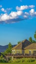 Vertical Home trees and mountain on a scenic landscape under blue sky and puffy clouds Royalty Free Stock Photo