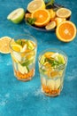 Vertical homemade lemonade with lemon, orange, sea buckthorn and mint in glasses on blue background, summer drink concept Royalty Free Stock Photo