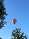 Vertical of a hot air balloon flying in the blue sky Royalty Free Stock Photo