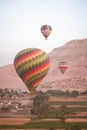 Vertical of hot air balloons flying above a barren landscape in Egypt