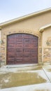 Vertical House exterior with a two car garage and concrete wall with stone bricks