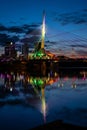 Vertical of the illuminated Esplanade Riel Footbridge reflected in the waters in Winnipeg, Canada.