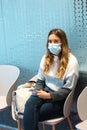 Woman wearing face mask waiting sitting in waiting room of spa center Royalty Free Stock Photo