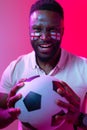 Vertical image of african american male soccer fan with flag of england in neon pink lighting Royalty Free Stock Photo