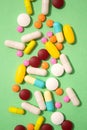 Vertical image of assorted multicolored medicine pills, capsules and tablets on green background. Immune system vitamins Royalty Free Stock Photo