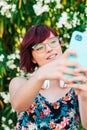 Vertical image of a beautiful young woman with glasses taking a selfie photo with her phone Royalty Free Stock Photo