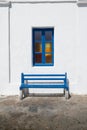 Bench under window against whitewashed wall in Mykonos, Greece. Royalty Free Stock Photo