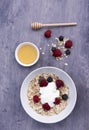 Vertical image of a bowl of Muesli with a pot of honey