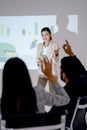 Vertical image of business man and woman raise their hands up to ask the question during presentation of Asian business woman in Royalty Free Stock Photo