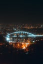 Vertical image of a bustling city skyline at night, featuring the Old Sava Bridge, Belgrade, Serbia